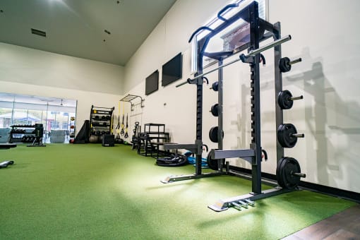 a gym with weights and other equipment on a green floor