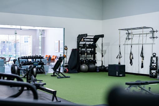 a gym with weights and other exercise equipment on a green carpet