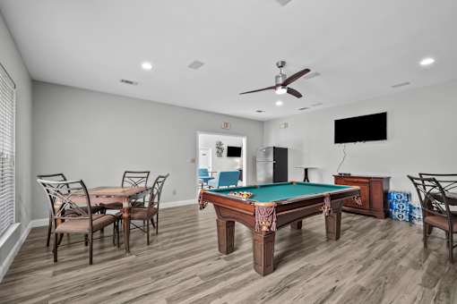 A room with a pool table and a television.
