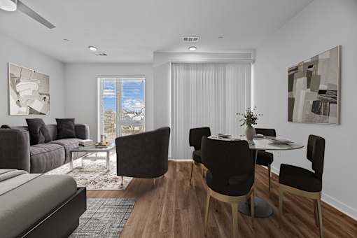 A modern living room with a grey sofa, a coffee table, and a dining table set up.