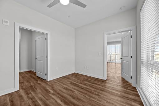 A room with a ceiling fan and wooden flooring.