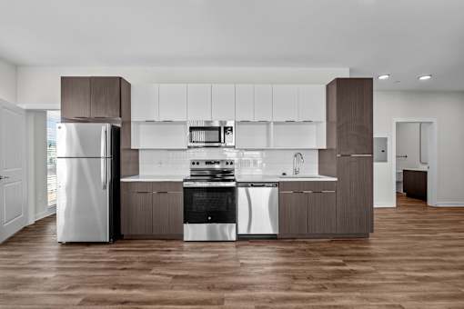 A modern kitchen with a refrigerator, stove, and oven.