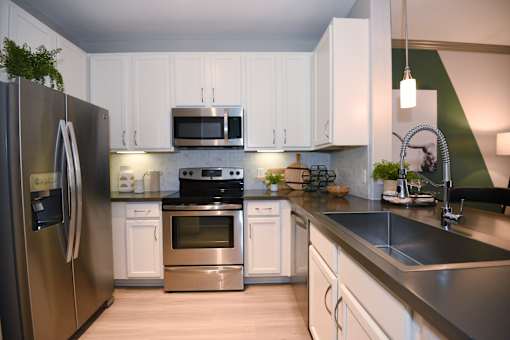 A modern kitchen with stainless steel appliances and white cabinets.