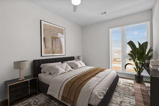A bedroom with a large bed and a painting on the wall.