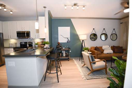 A modern kitchen with a bar stool and a chair.