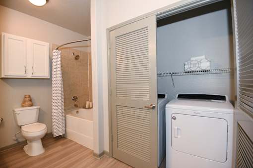 A white toilet sits in a bathroom next to a white cabinet.