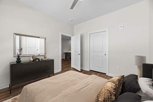 A bedroom with a bed, dresser, and mirror.