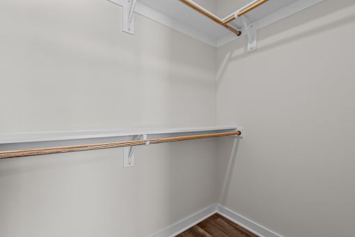 A white wall with a brown pipe and a white shelf.