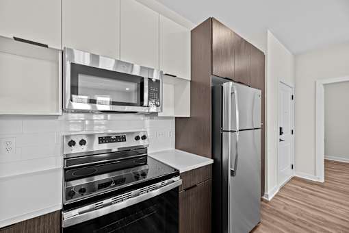 A modern kitchen with a stainless steel refrigerator and oven.