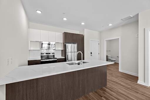 A modern kitchen with a white countertop and wooden cabinets.