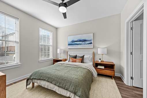 A bedroom with a bed, nightstands, and a ceiling fan.
