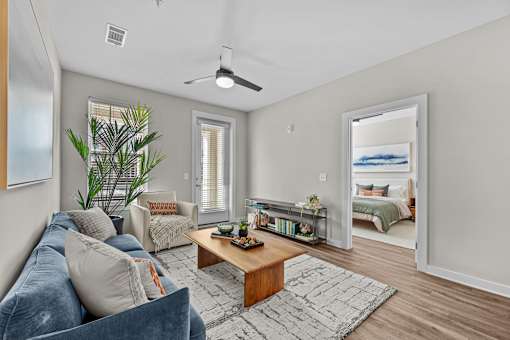 A living room with a blue couch and a wooden coffee table.