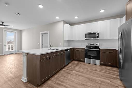 A modern kitchen with wooden floors and white countertops.