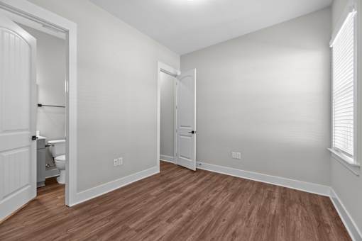 A room with wooden flooring and white walls.