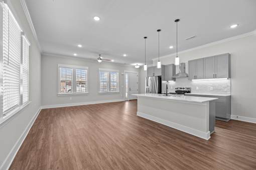 A spacious kitchen with wooden floors and a large island.