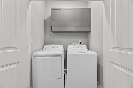 A white washing machine and dryer in a laundry room.