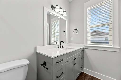 A bathroom with a white sink and a large mirror.