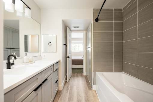A bathroom with a white tub and a white sink.