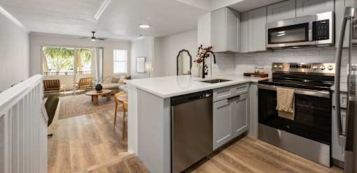 A modern kitchen with a stainless steel oven and a wooden floor.