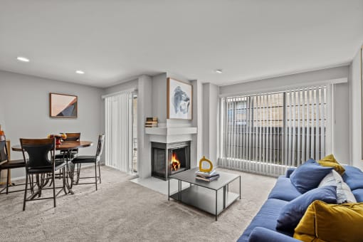 a living room with a fireplace and a table with chairs