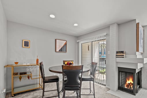 a living room with a fireplace and a table and chairs