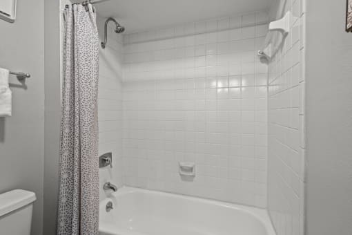 a bathroom with a white tub and a white tiled shower