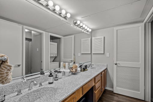 a bathroom with a large mirror and a double sink