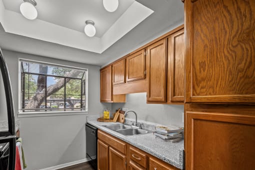 a kitchen with wooden cabinets and a sink and a window