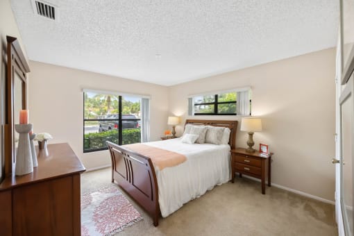 a bedroom with a bed and two windows