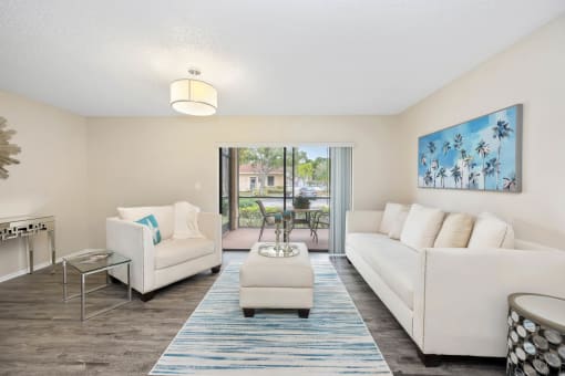 a living room with two white couches and a blue rug