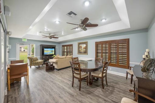 a living room and dining room with blue walls and a coffered ceiling