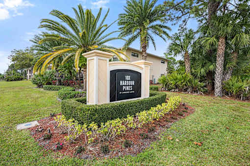 A sign that says "Hillcrest Homes" is in front of some trees.