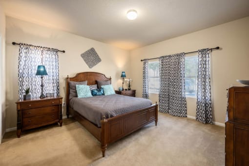 A bedroom with a bed, dresser, and nightstand.