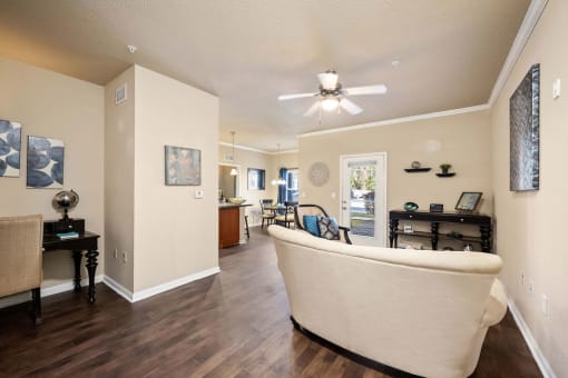 A living room with a white sofa and a wooden floor.