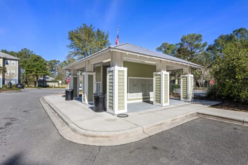 A small building with a flag on top is surrounded by a metal fence.