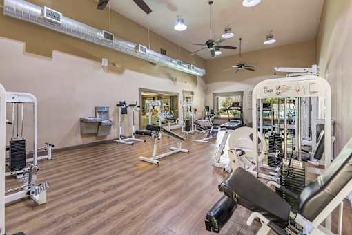 A gym with a variety of equipment including weights and machines.