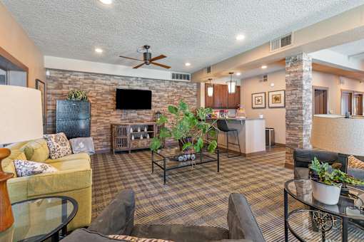 A living room with a stone fireplace and a flat screen TV mounted above it.