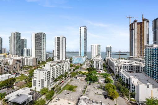 a city skyline with tall buildings and a body of water