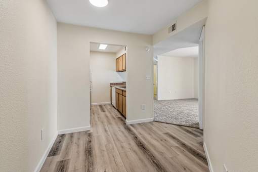 A room with wooden flooring and white walls.