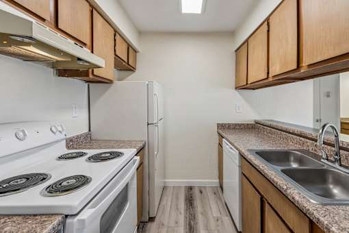 A kitchen with a white stove top oven and a white refrigerator.