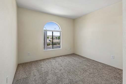 A room with a carpeted floor and a large window.