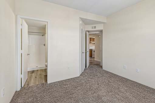 A room with carpeted floor and two open doors.