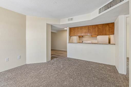 A room with a carpeted floor and a wooden cabinet.