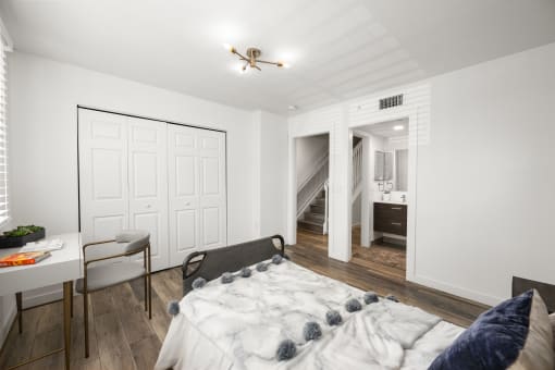 a bedroom with a large bed and a desk with a chair