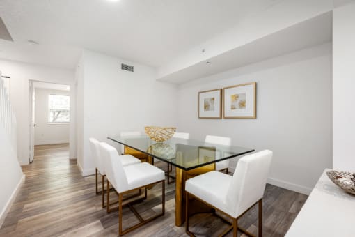 a dining room with a glass table and white chairs