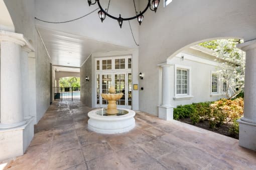 a courtyard with a fountain in the middle of a white house