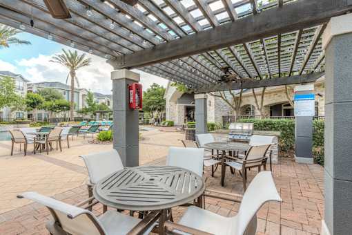 A patio with a table and chairs under a roof.