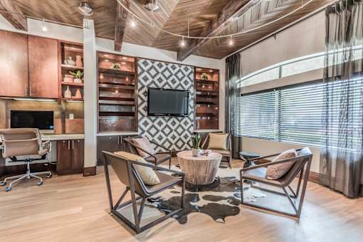 A modern living room with a wooden floor and a television mounted on the wall.