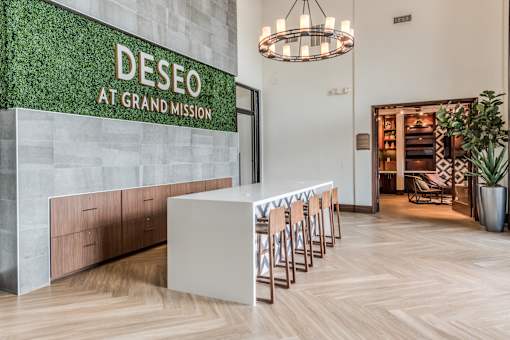 A reception area with a green wall and a white reception desk.