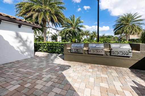 A row of grills are on a patio.